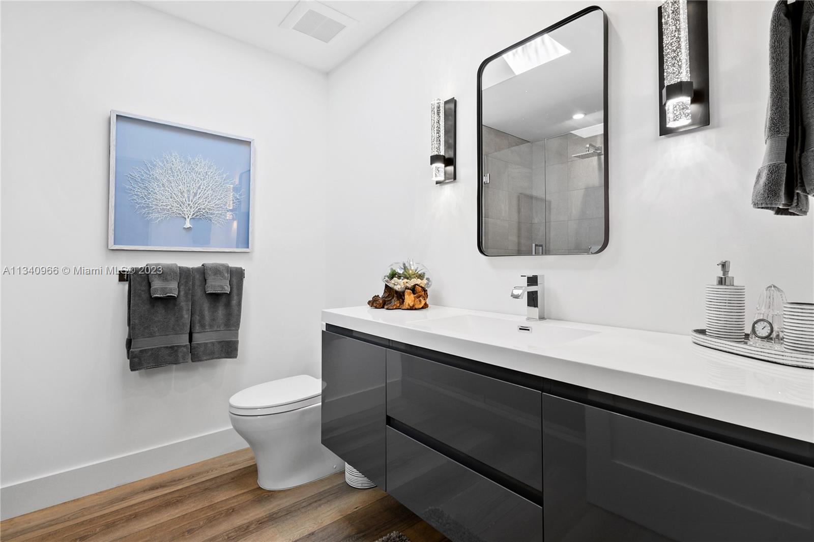 136 Sand Pine Drive Jupiter, FL 33477 - Photo 16 of 30 a bathroom with a sink and a mirror