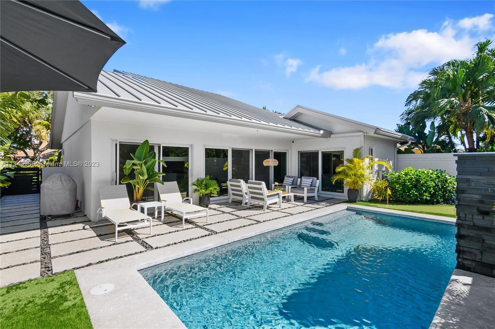 136 Sand Pine Drive Jupiter, FL 33477 - Photo 23 of 30 a view of a house with backyard sitting area and garden