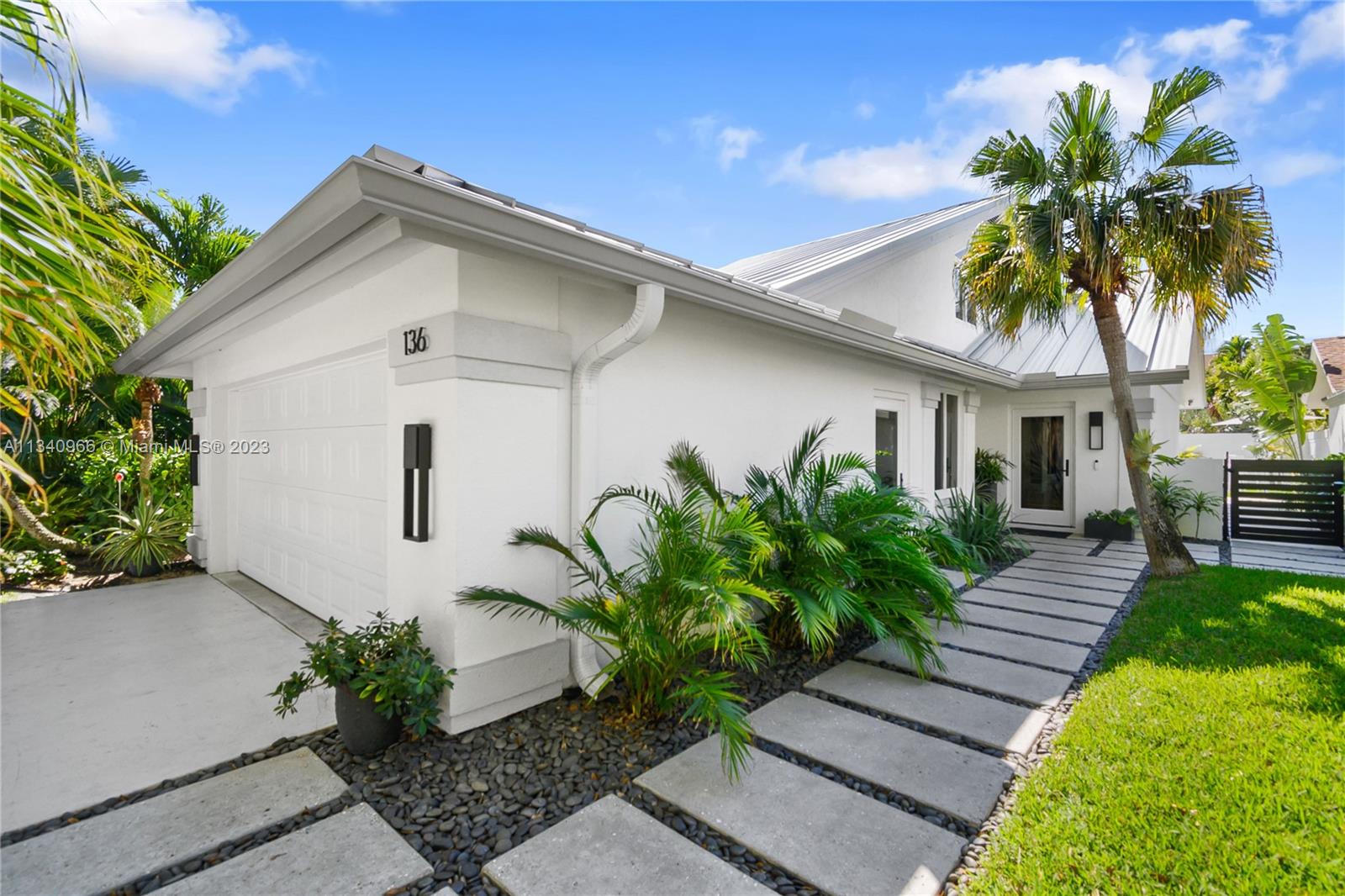 136 Sand Pine Drive Jupiter, FL 33477 - Photo 25 of 30 a front view of a house with garden