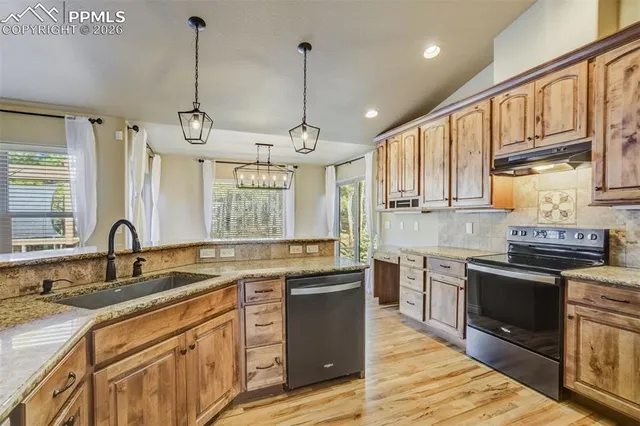 a kitchen with stainless steel appliances granite countertop a sink stove and refrigerator