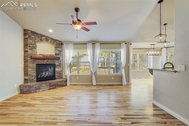 a view of an empty room with a fireplace and a window
