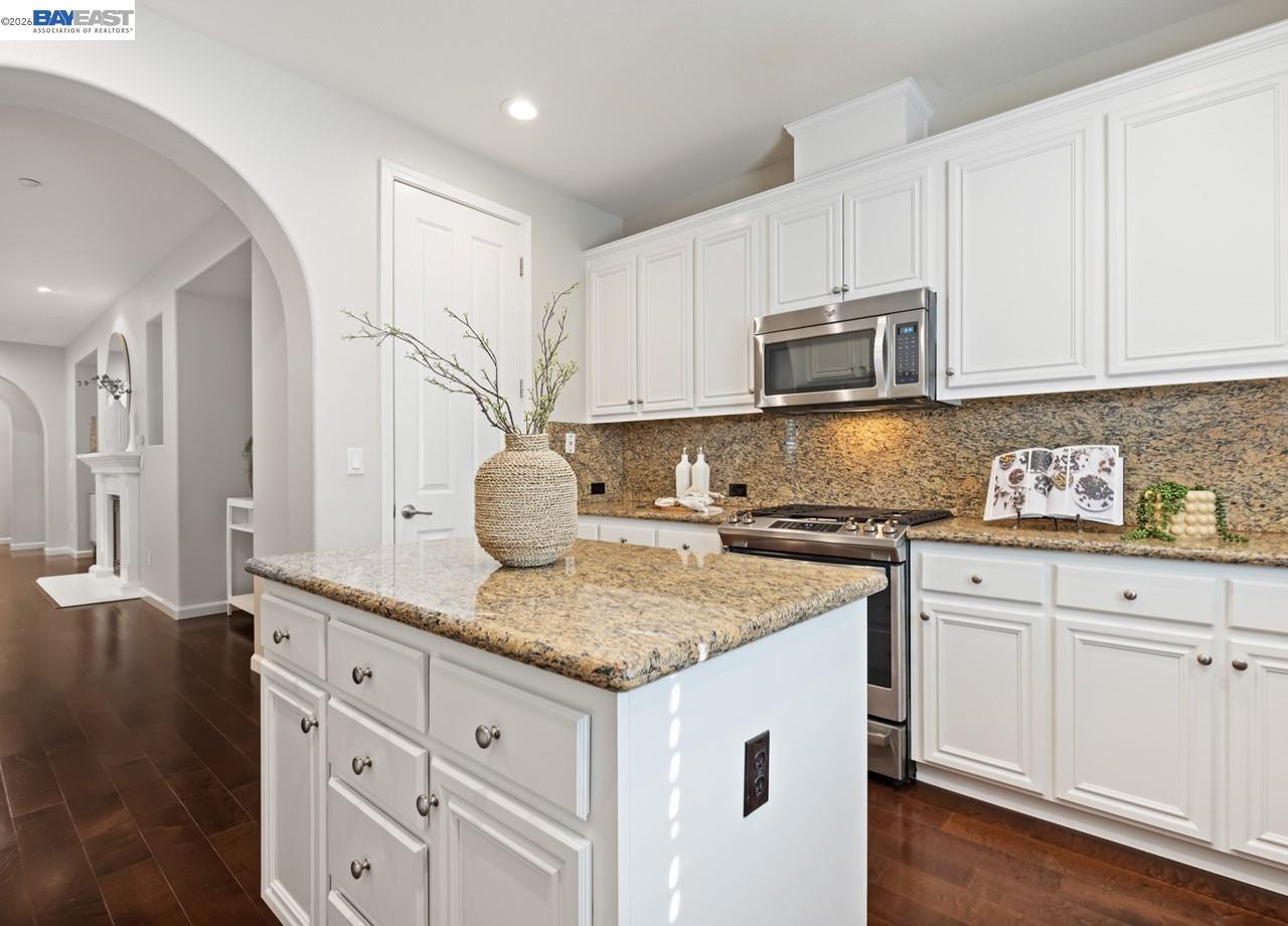 a kitchen with granite countertop a sink stove and cabinets