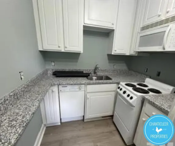 a kitchen with stainless steel appliances granite countertop white cabinets and a stove