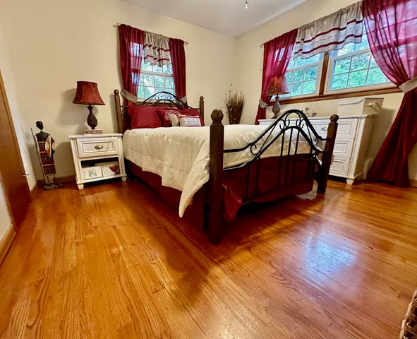 a bedroom with a bed and a dresser next to a window