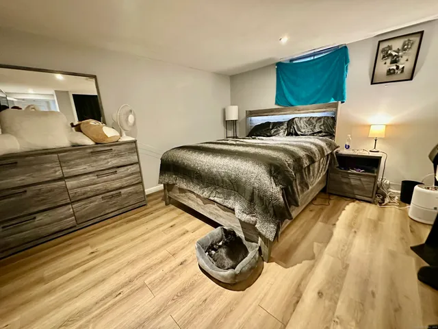 a bedroom with a bed and wooden floor