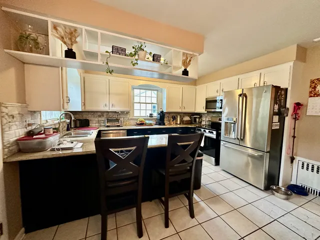 a kitchen with stainless steel appliances granite countertop a sink and a refrigerator