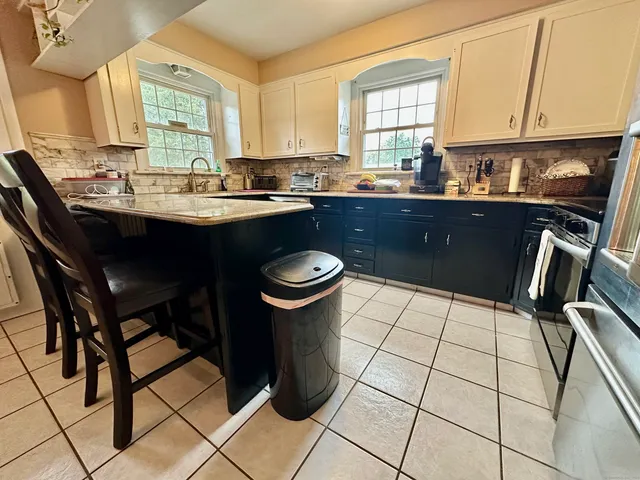 a kitchen with a sink a stove a window and dining table