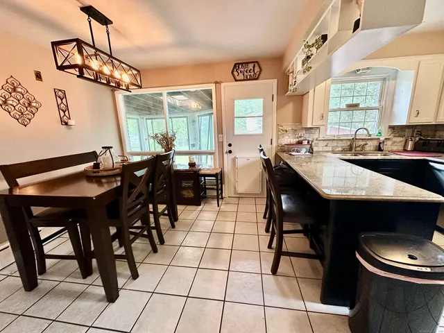 a kitchen with a sink and chairs