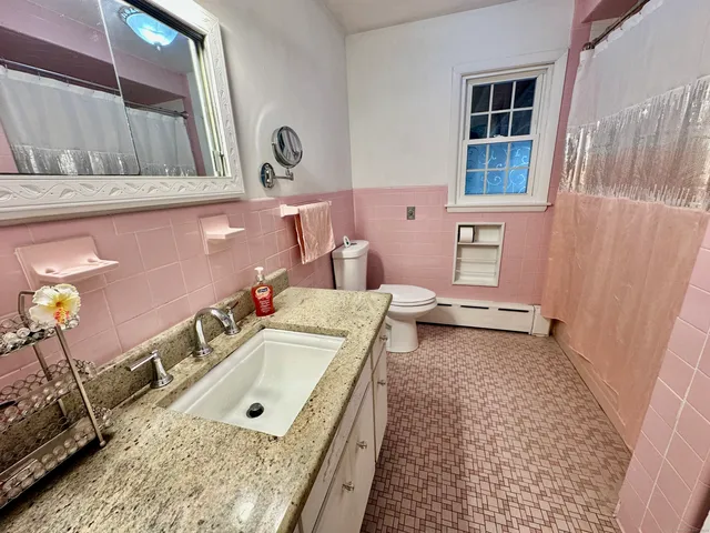 a bathroom with a tub sink and mirror