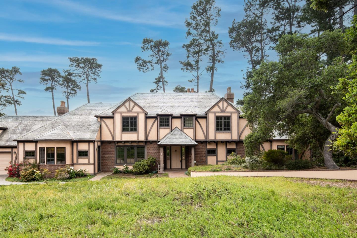 a front view of a house with a garden and trees