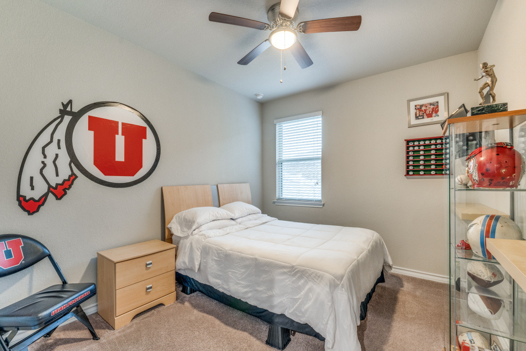 5921 Lehman Way Austin, TX 78747 - Photo 15 of 25 Well-lit bedroom with soft carpet and a convenient ceiling fan for year-round comfort.