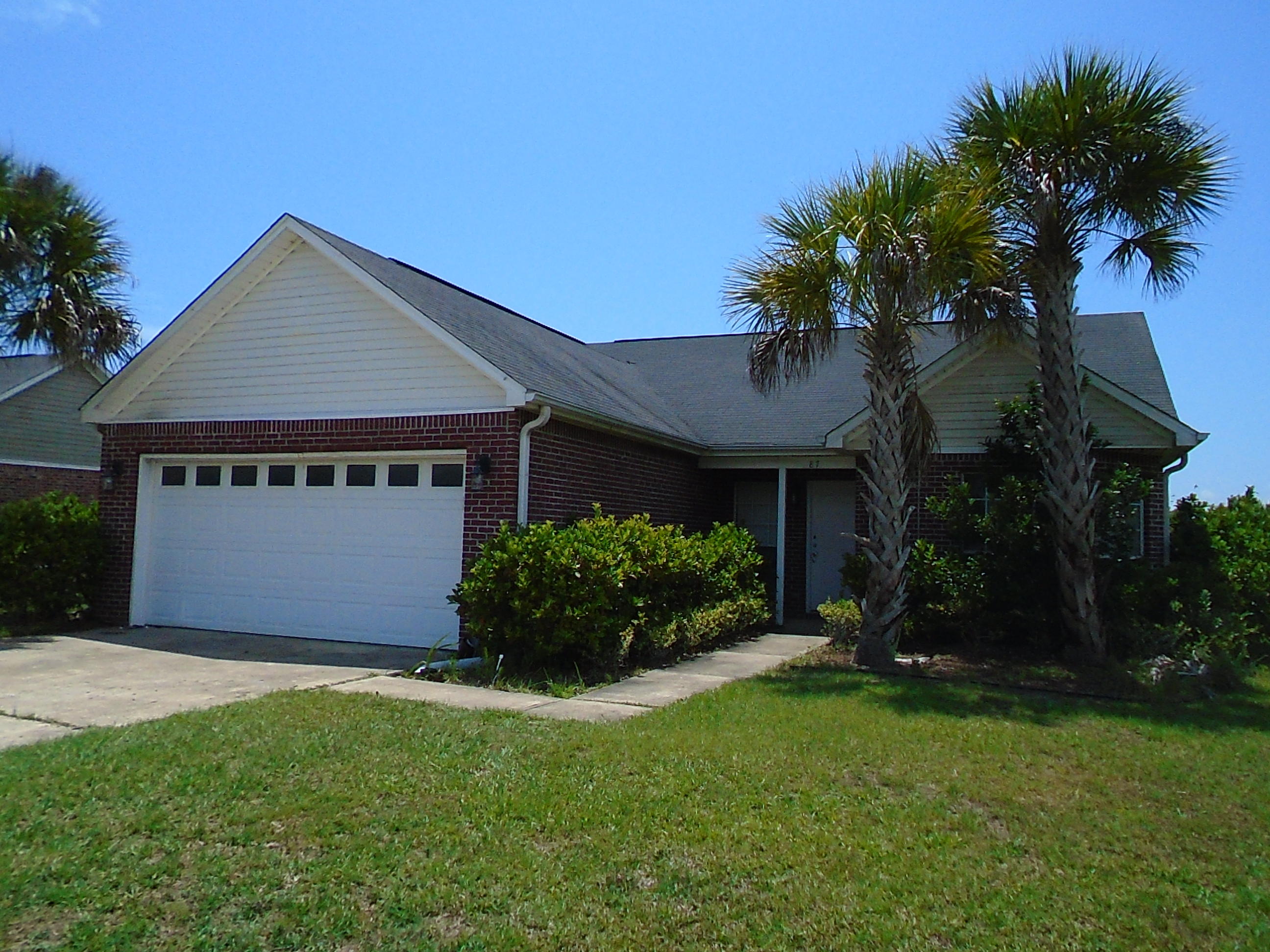 87 Tropical Way Freeport, FL 32439 - Photo 1 of 12 a front view of a house with a garden