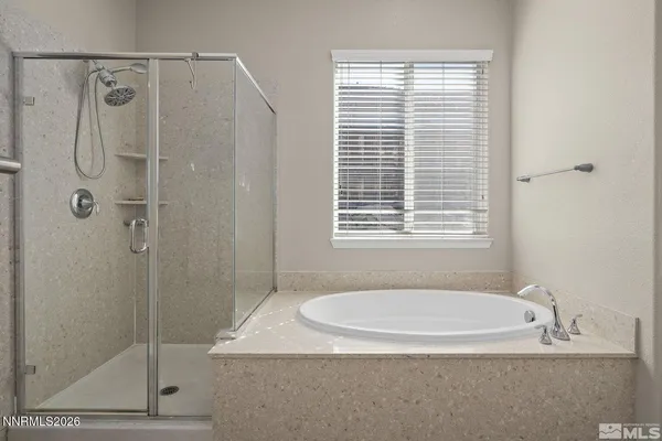 a bathroom with a granite countertop a shower a window and a sink