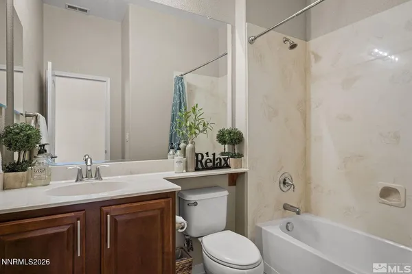 a bathroom with a granite countertop sink a toilet and shower