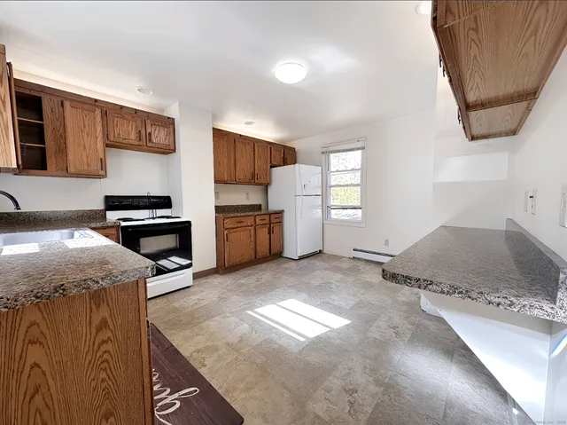 a kitchen with a stove a refrigerator and a sink