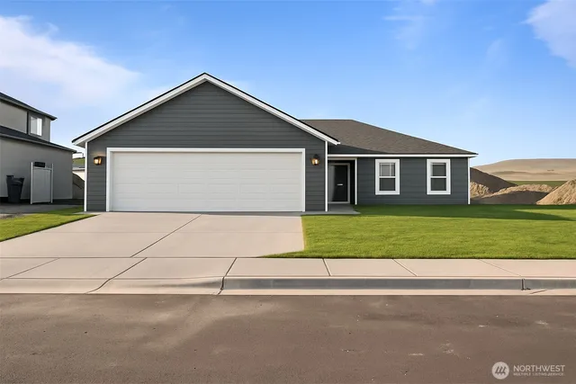 a front view of a house with a garden and garage