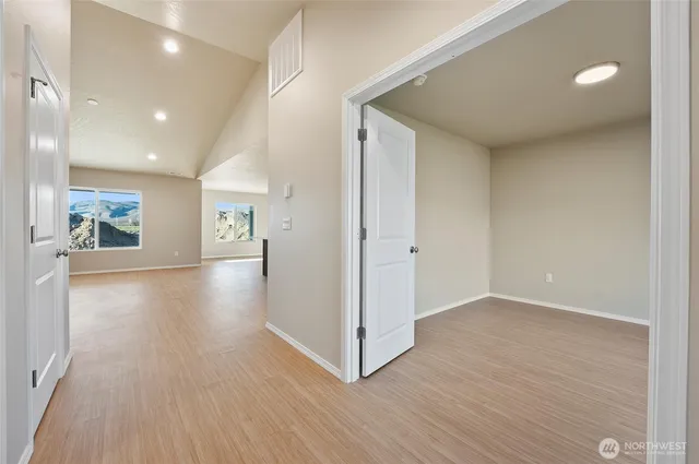 a view of a hallway with wooden floor and a living room