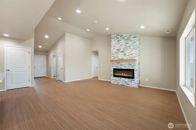 a view of an empty room with a fireplace and a window
