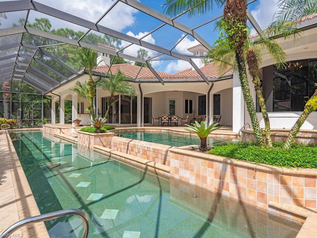 5140 Tamarind Ridge Drive Naples, FL 34119 - Photo 22 of 25 Expansive property featuring a Mediterranean-style residence with a terracotta roof, surrounded by mature trees and lush landscaping