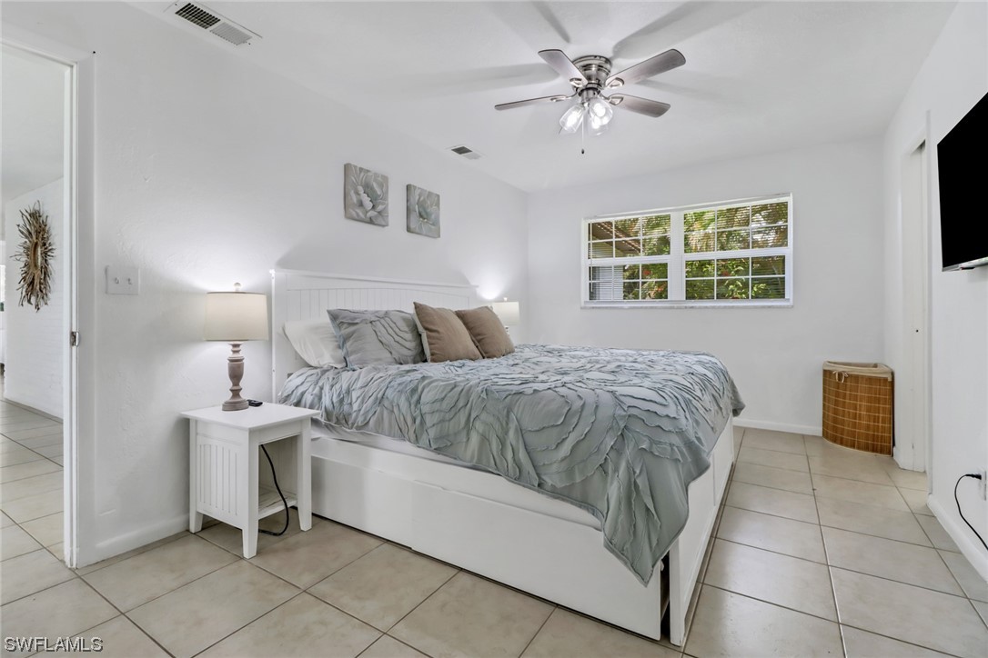 1192 Moody Road North Fort Myers, FL 33903 - Photo 17 of 29 a bedroom with a bed and a chandelier
