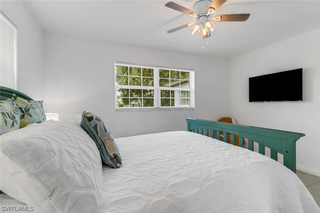 1192 Moody Road North Fort Myers, FL 33903 - Photo 21 of 29 a bedroom with a bed a flat screen tv and a window
