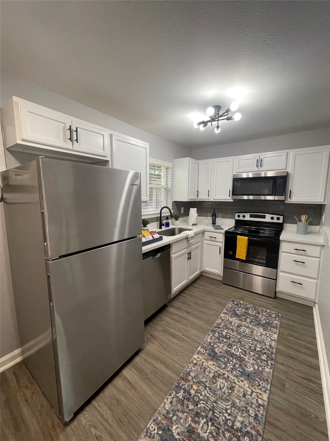 1225 West 25th Street, Unit 2 Houston, TX 77008 - Photo 1 of 6 a kitchen with a refrigerator a stove top oven and cabinets
