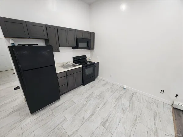 a kitchen with granite countertop a refrigerator stove and microwave