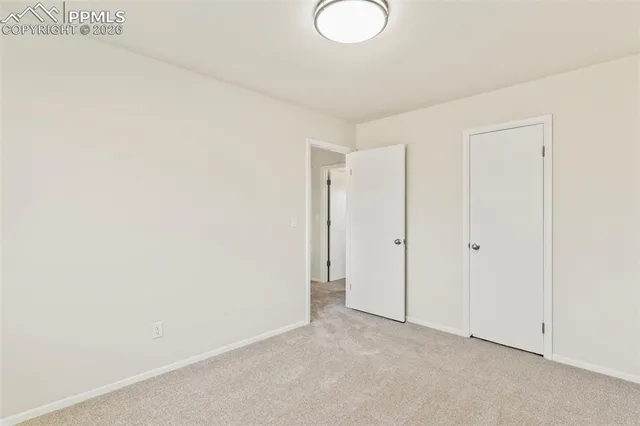 a view of a room that has a window and a fan