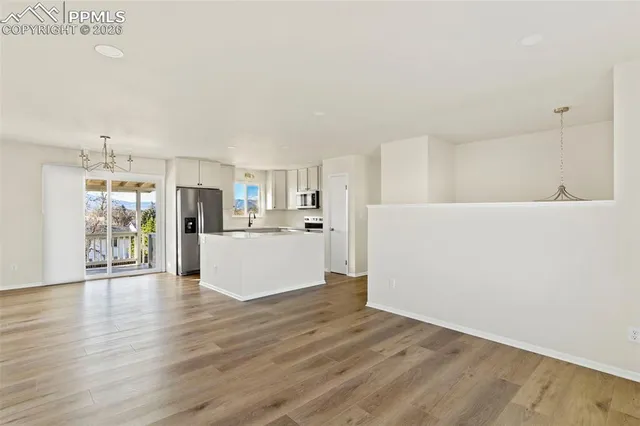 a view of a kitchen with wooden floor and electronic appliances