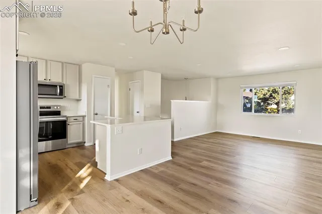 a view of a kitchen with wooden floor and electronic appliances