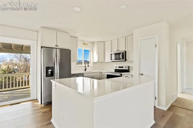 a kitchen with stainless steel appliances granite countertop a refrigerator a stove a sink and dishwasher