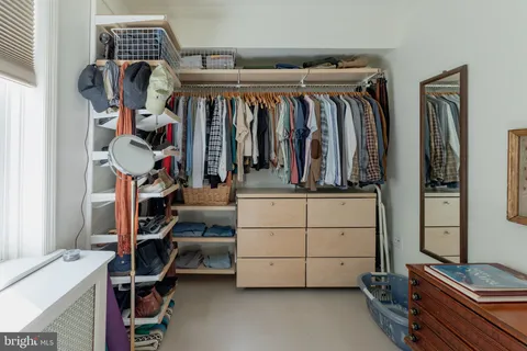 a view of walk in closet with clothes and shoes