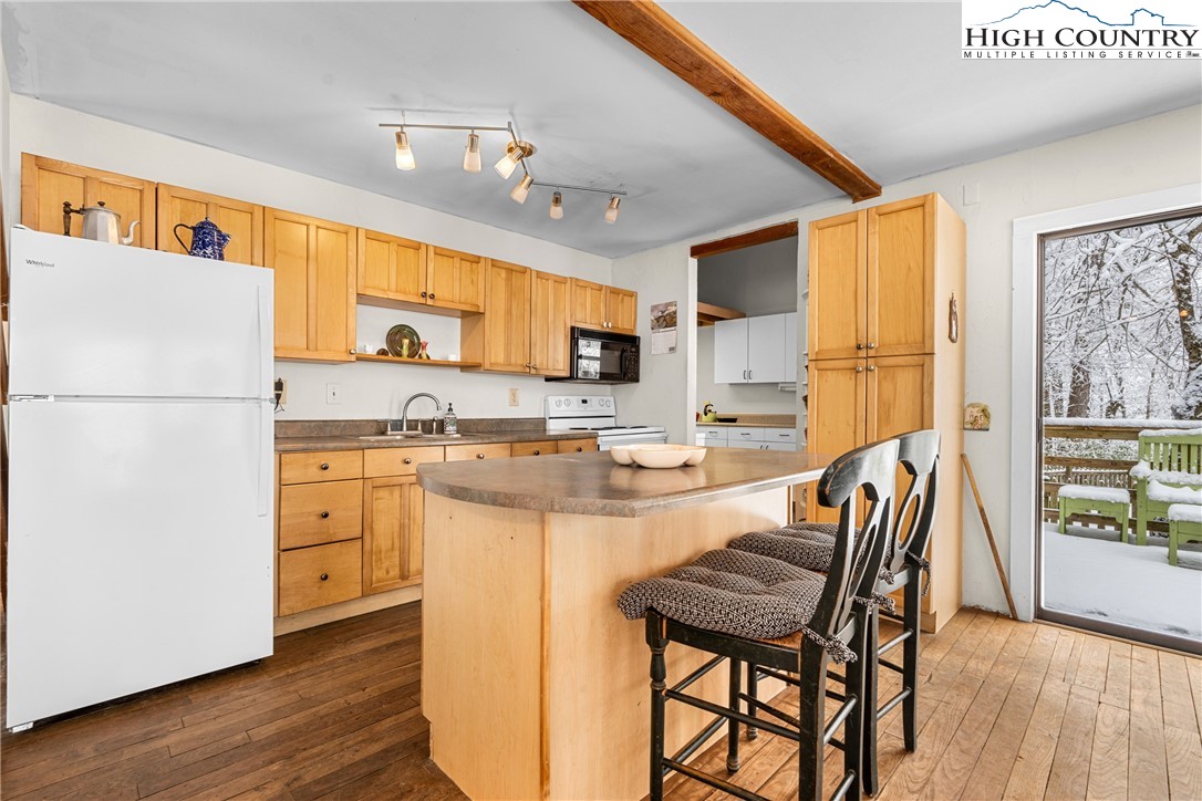 1355 Pine Run Road Boone, NC 28607 - Photo 9 of 37 a kitchen with a refrigerator a stove a sink and white cabinets with wooden floor