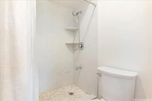 a bathroom with a shower a toilet and sink