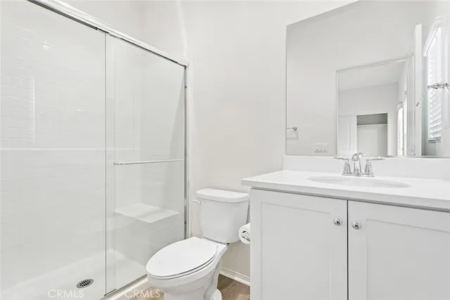 a bathroom with a granite countertop sink toilet a mirror and shower