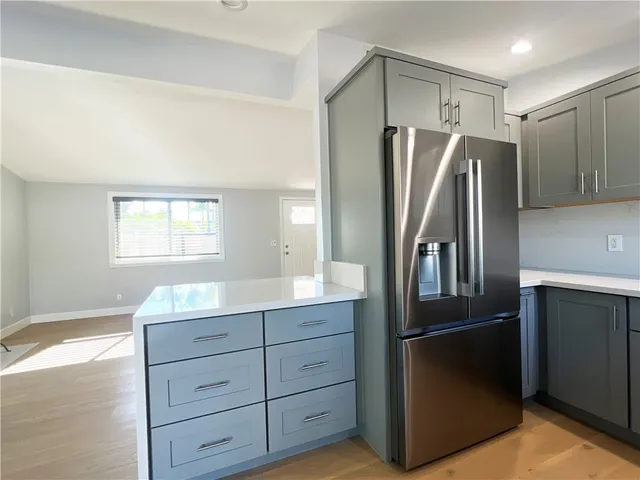 a kitchen with cabinets stainless steel appliances and window