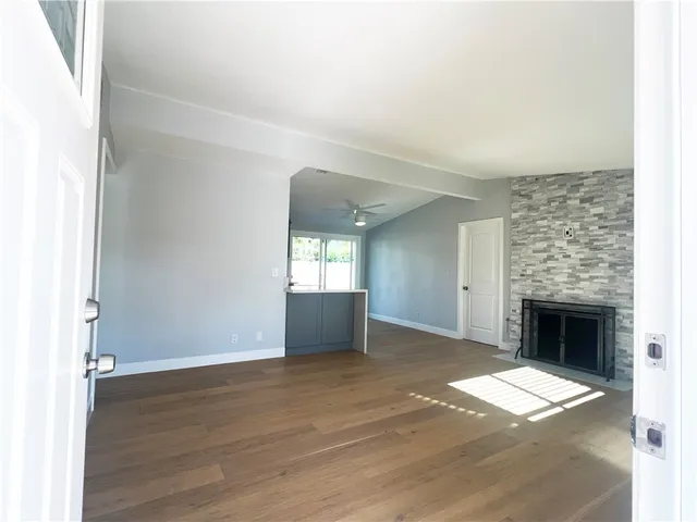 an empty room with windows and fireplace