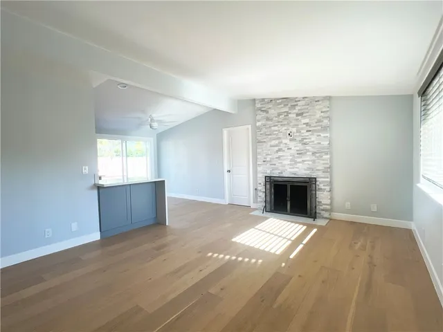 a view of an empty room with a fireplace and a window