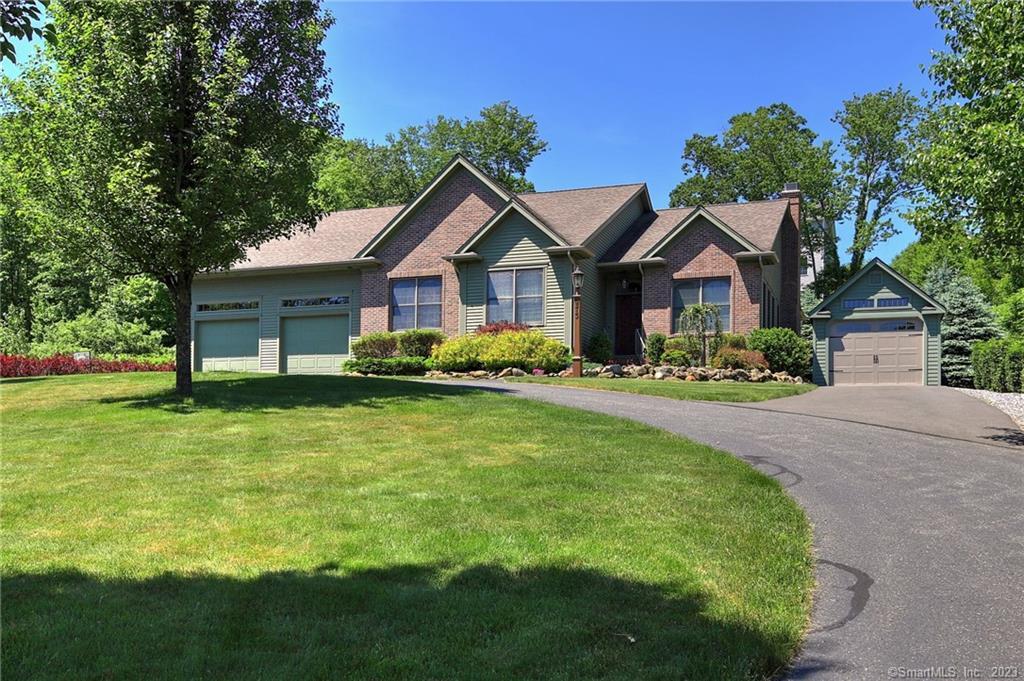 973 Woodtick Road Wolcott, CT 06716 - Photo 1 of 1 a front view of a house with a garden and trees