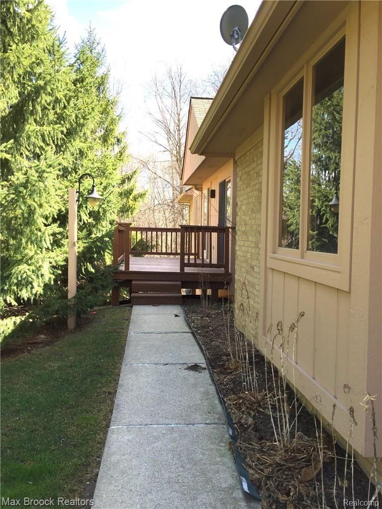 21990 River Ridge Trail, Unit 70 Farmington, MI 48335 - Photo 5 of 27 Sidewalk with treed setting to front entrance