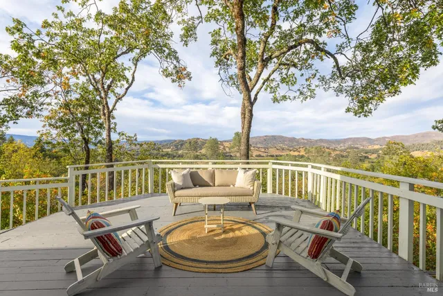 an outdoor living room with furniture and a floor to ceiling window