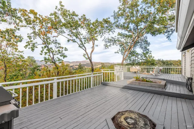 a view of a balcony with wooden floor and fence