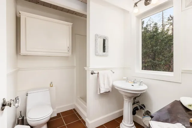 a bathroom with a sink toilet and a mirror