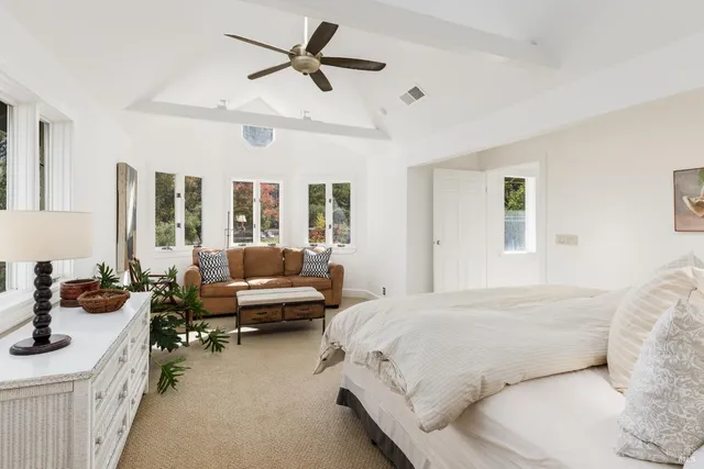 a bedroom with a bed a couch and a large window