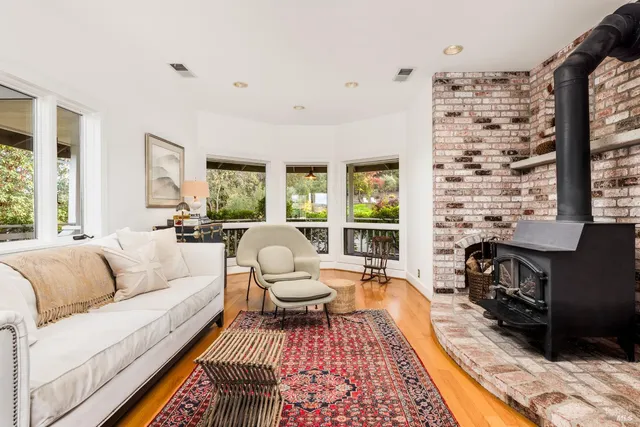 a living room with fireplace furniture and a rug