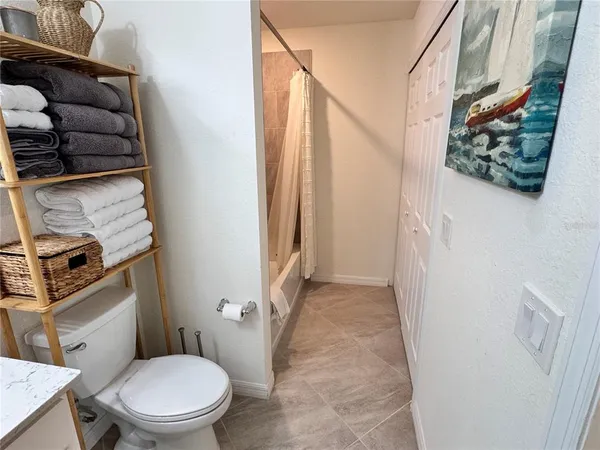 a white toilet sitting next to a shower curtain