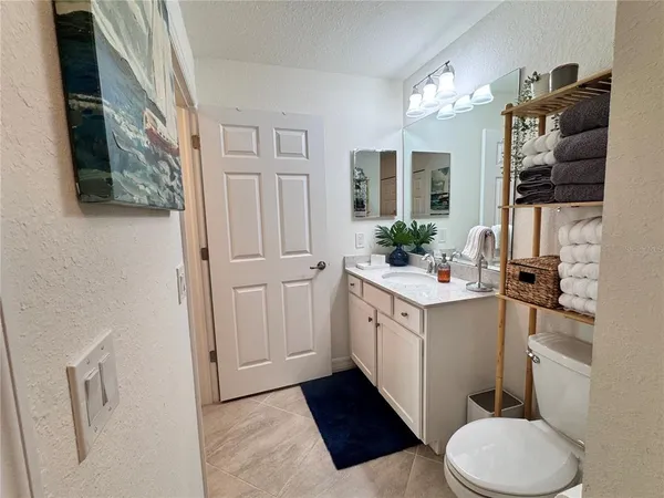 a bathroom with a sink vanity granite and toilet