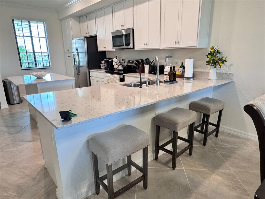 17724 Gawthrop Drive, Unit 304 Bradenton, FL 34211 - Photo 17 of 38 a kitchen with stainless steel appliances granite countertop a table chairs in it and a window