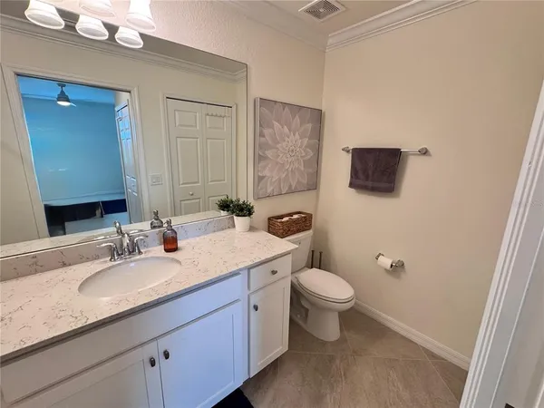 a bathroom with a granite countertop sink a toilet and mirror