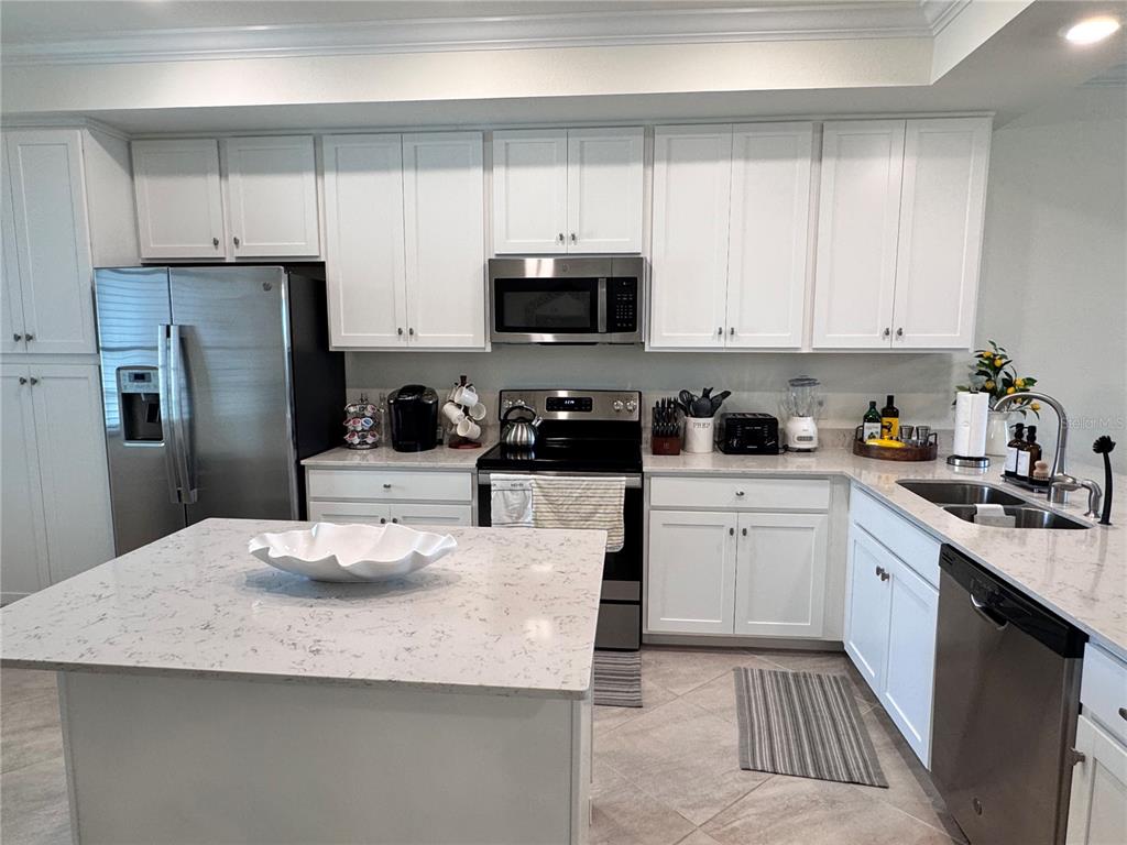 17724 Gawthrop Drive, Unit 304 Bradenton, FL 34211 - Photo 5 of 38 a kitchen with granite countertop white cabinets and stainless steel appliances